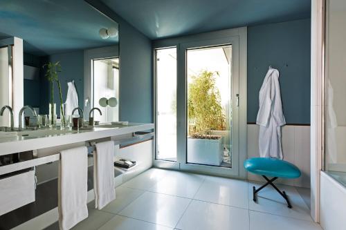 a bathroom with blue walls and a blue chair at The Hotel Lucerne, Autograph Collection in Luzern