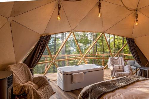 a room in a tent with a tub and chairs at Alpin D'Hôme Hôtel & Spa in Les Orres