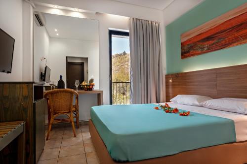 a bedroom with a bed with flowers on it at Hotel Pavlou in Poros