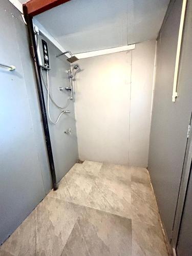a small bathroom with a shower and a door at Kenno's Korner in Weligama
