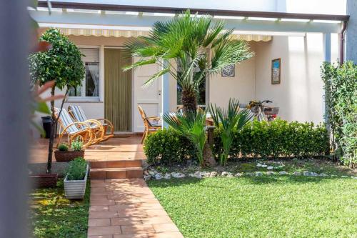ein Haus mit einer Terrasse mit Stühlen und Pflanzen in der Unterkunft R28 Trilocale con giardino a due passi dal mare in Marcelli