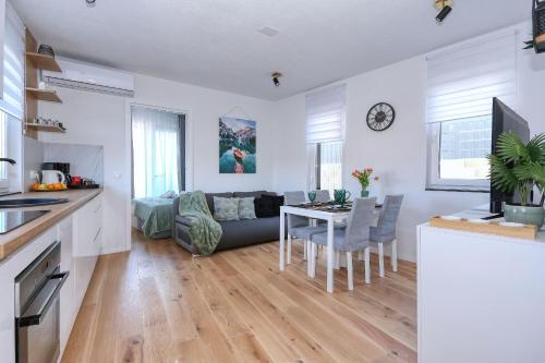 cocina y sala de estar con sofá y mesa en Apartment Garden, en Zadar