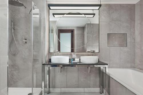 a bathroom with two sinks and a mirror at Aloft Birmingham Eastside in Birmingham