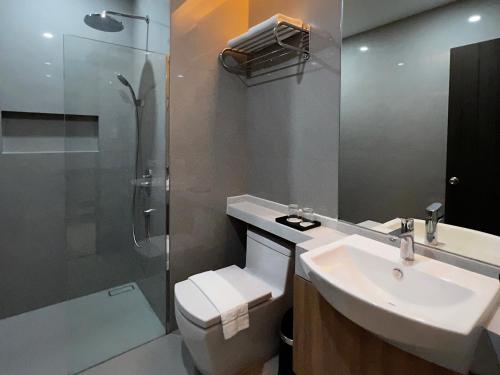 a bathroom with a toilet and a sink and a shower at The Litton Hotel by Carterson in Naga