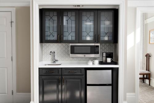a kitchen with black cabinets and a microwave at Marriott Vacation Club Pulse at Custom House, Boston in Boston