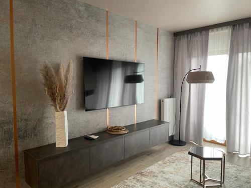 a living room with a television on a wall at GOLD Apartment Centrum garaż in Gliwice