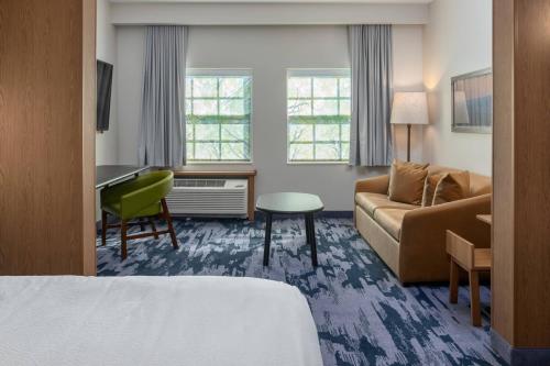 a hotel room with a bed and a couch and a desk at Fairfield Inn & Suites Morganton Historic Downtown in Morganton