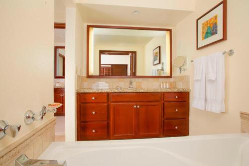 a bathroom with a tub and a large mirror at Marriott's Ko Olina Beach Club in Kapolei