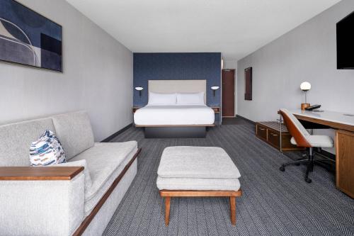 Habitación de hotel con cama, sofá y escritorio en Courtyard Austin South, en Austin