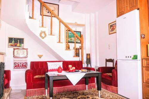 a living room with a red couch and a table at La Casa Di Silvia in Apolakkiá