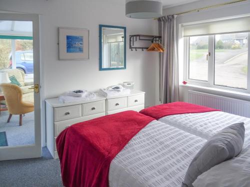 sypialnia z łóżkiem z czerwonym kocem w obiekcie The Churn w mieście Bisley