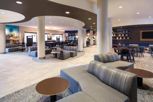 a lobby of a hotel with couches and tables at Courtyard by Marriott Fort Lauderdale Airport & Cruise Port in Dania Beach