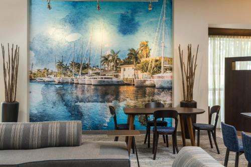 a living room with a painting of a harbor at Courtyard by Marriott Fort Lauderdale Airport & Cruise Port in Dania Beach