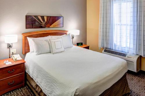 Habitación de hotel con cama grande y ventana en TownePlace Suites Dallas Las Colinas en Irving