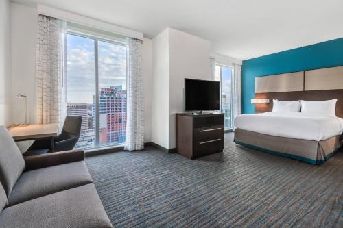Residence Inn by Marriott Charlotte City Center في تشارلوت: غرفة فندقية بسرير وتلفزيون بشاشة مسطحة