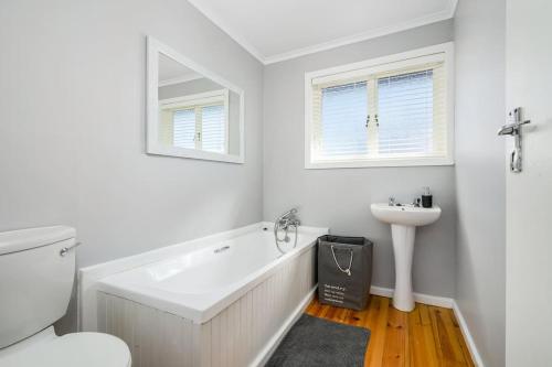 a white bathroom with a tub and a sink at The Slipway in Colchester