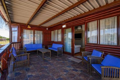 a porch with blue chairs and tables and windows at The Slipway in Colchester
