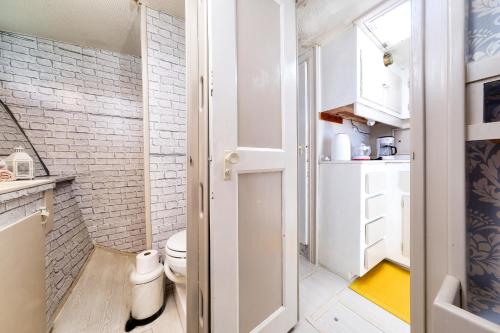 a small bathroom with a toilet and a brick wall at HouseBoat Isurus Quinto in Puerto Calero