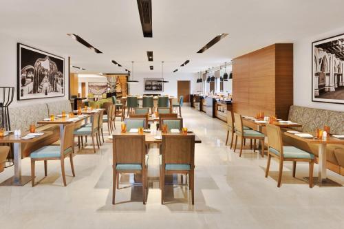comedor con mesas y sillas de madera en Fairfield by Marriott Bengaluru Whitefield, en Bangalore