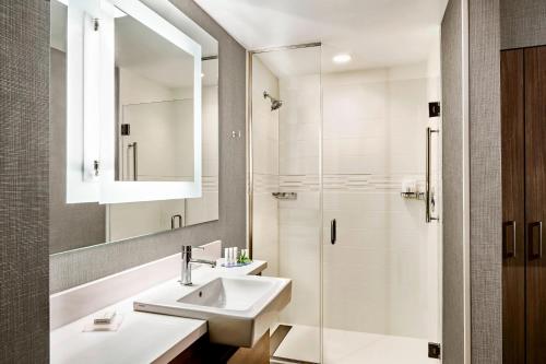 a white bathroom with a sink and a shower at SpringHill Suites by Marriott Lake Charles in Lake Charles