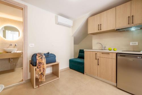 a kitchen with wooden cabinets and a blue couch at Pargabella apartments in Parga