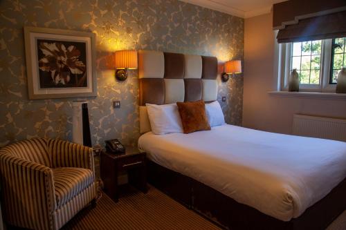 a bedroom with a large bed and a chair at Hopping Hare in Northampton