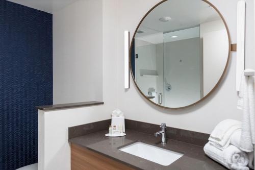 La salle de bains est pourvue d'un lavabo et d'un miroir. dans l'établissement Fairfield Inn & Suites by Marriott Atlanta Marietta, à Marietta