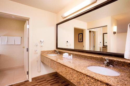 a bathroom with two sinks and a large mirror at Courtyard Boston Woburn/Boston North in Woburn