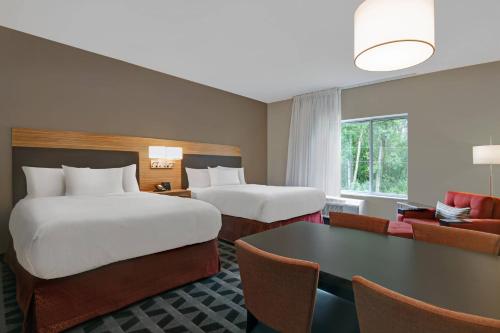 Cette chambre comprend 2 lits et une table. dans l'établissement TownePlace Suites By Marriott Lima, à Lima