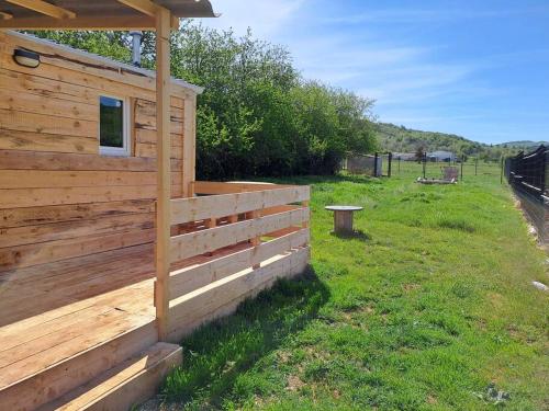 uma cabina de madeira num campo com uma cerca em A la ferme dans le Luberon 