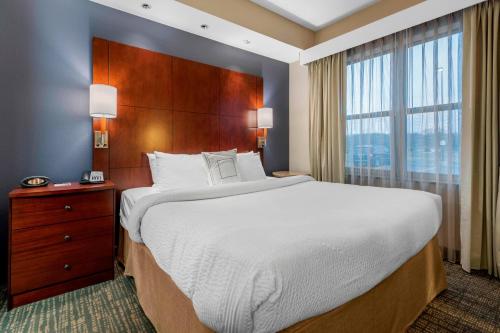 a bedroom with a large bed and a large window at Residence Inn Columbus in Columbus