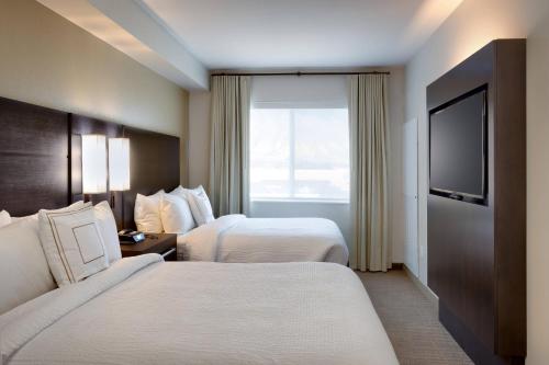 a hotel room with two beds and a flat screen tv at Residence Inn by Marriott Provo South University in Provo