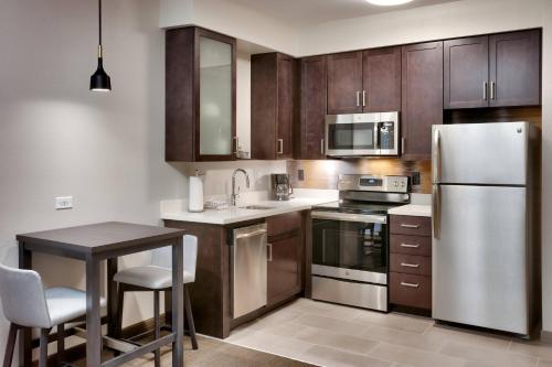 a kitchen with stainless steel appliances and wooden cabinets at Residence Inn by Marriott Provo South University in Provo