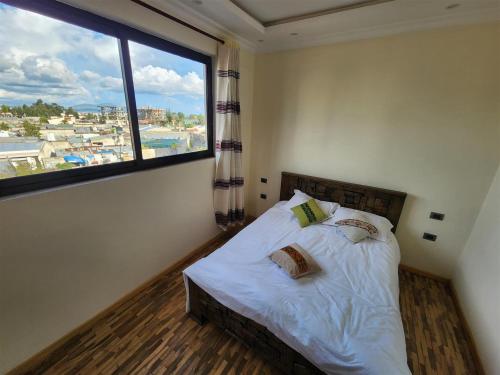 a bedroom with a bed with a large window at Sora Addis BnB in Addis Ababa