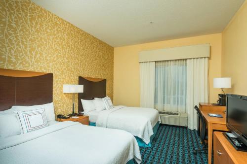 a hotel room with two beds and a flat screen tv at Fairfield Inn and Suites by Marriott Augusta in Augusta