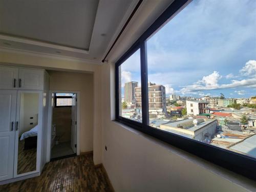 a room with a large window with a view of a city at Sora Addis BnB in Addis Ababa