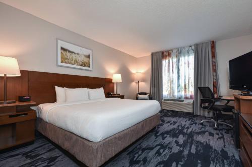 a hotel room with a bed and a flat screen tv at Fairfield Inn by Marriott Columbia Northwest / Harbison in Columbia
