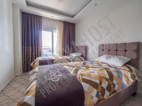 a bedroom with two beds and a sign on the wall at Calypso Residence in Kestel Alanya C21 in Alanya