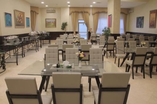 a dining room with tables and chairs in a room at Le Vendome Hotel in Amman