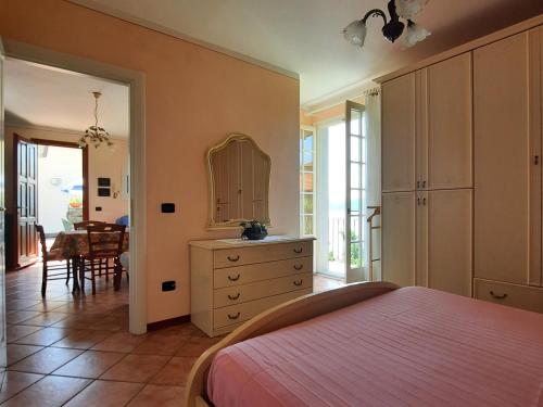 a bedroom with a bed and a dresser and a table at Appartamento Porto 2 in Cannero Riviera