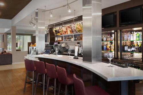a bar with bar stools and wine bottles at Courtyard by Marriott Fishkill in Fishkill