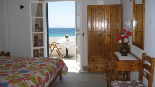 Aronis Plaka Naxos في بلاكا: غرفة نوم مع سرير وإطلالة على المحيط