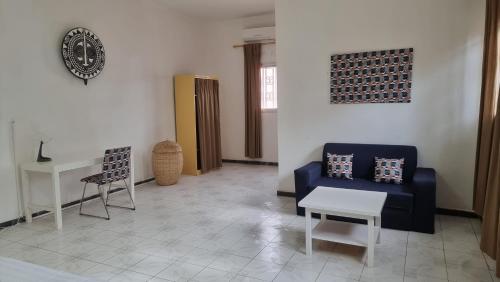 a living room with a blue couch and a table at Le k in Nouakchott
