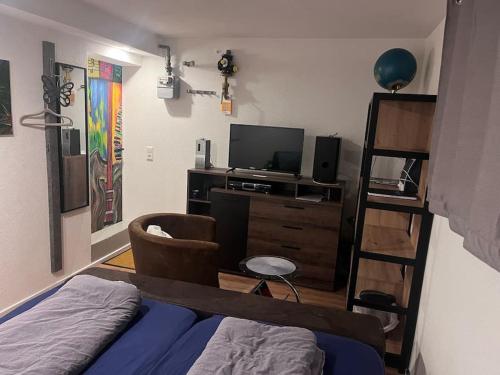 ein Schlafzimmer mit einem Bett, einem TV und einem Regal in der Unterkunft Kleine Wohnung im - Konzept Flieger - 2 Stockwerke in Tettnang