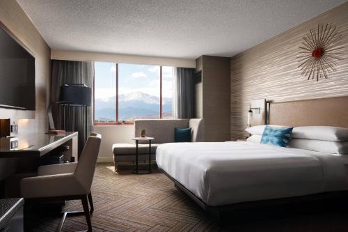 een hotelkamer met een groot bed en een bureau bij Colorado Springs Marriott in Colorado Springs