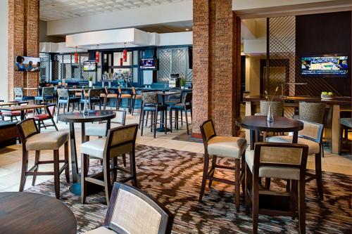 a restaurant with tables and chairs and a bar at Colorado Springs Marriott in Colorado Springs