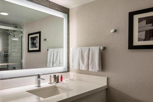 a bathroom with a sink and a large mirror at Boston Marriott Newton in Newton