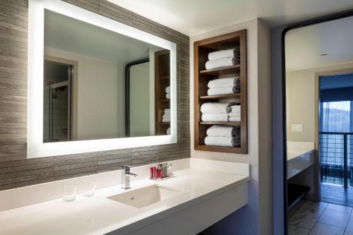 a bathroom with a sink and a mirror and towels at Boston Marriott Newton in Newton