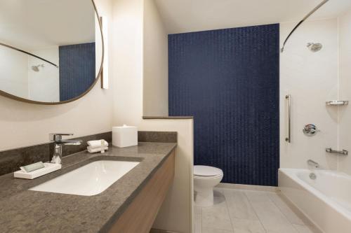 a bathroom with a sink and a toilet and a mirror at Fairfield by Marriott Inn & Suites Rockaway in Rockaway