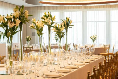 a long table with glasses and flowers in a room at Sheraton Mall of the Emirates Hotel, Dubai in Dubai